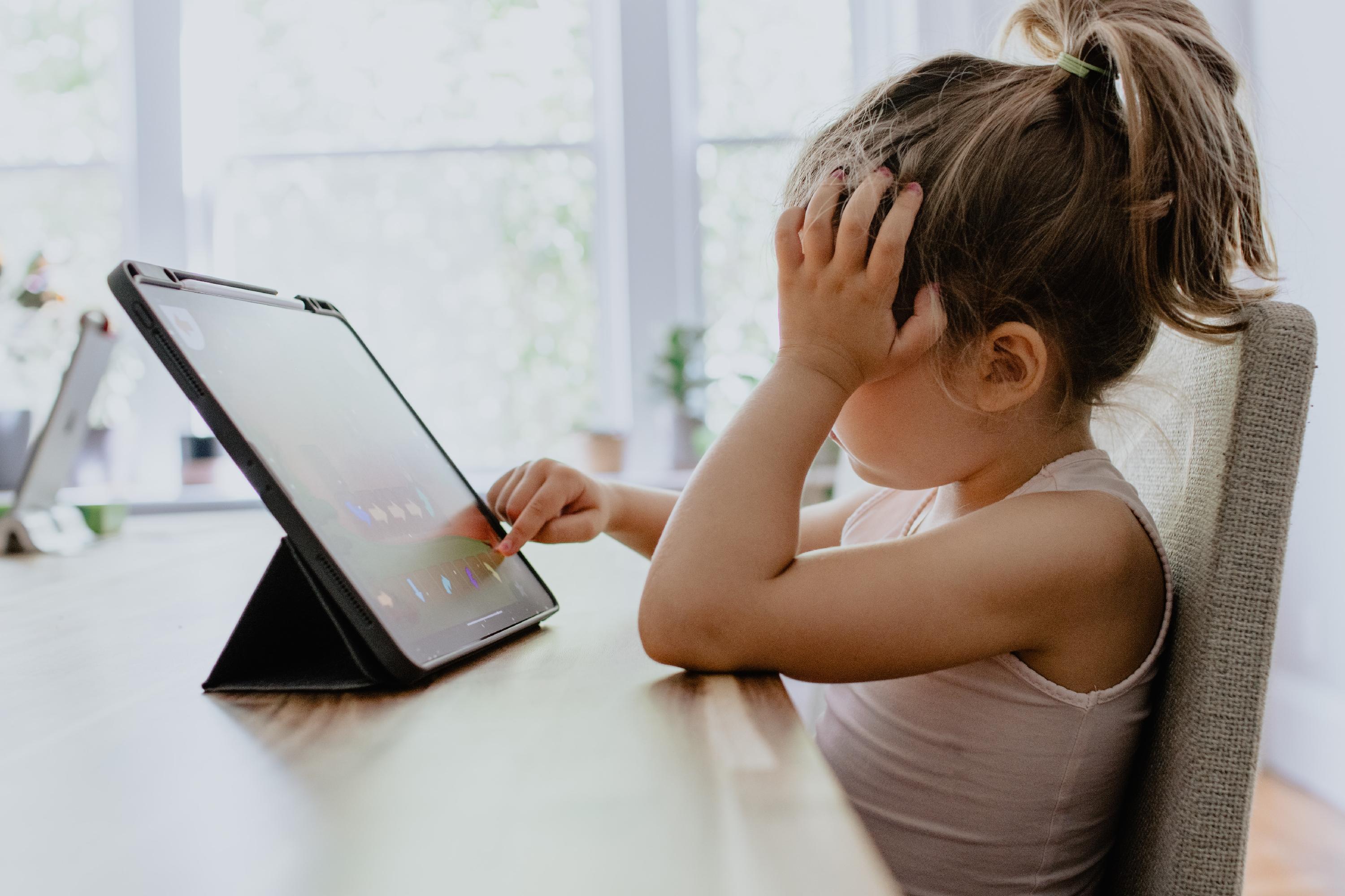Little girl looking at online school on iPad